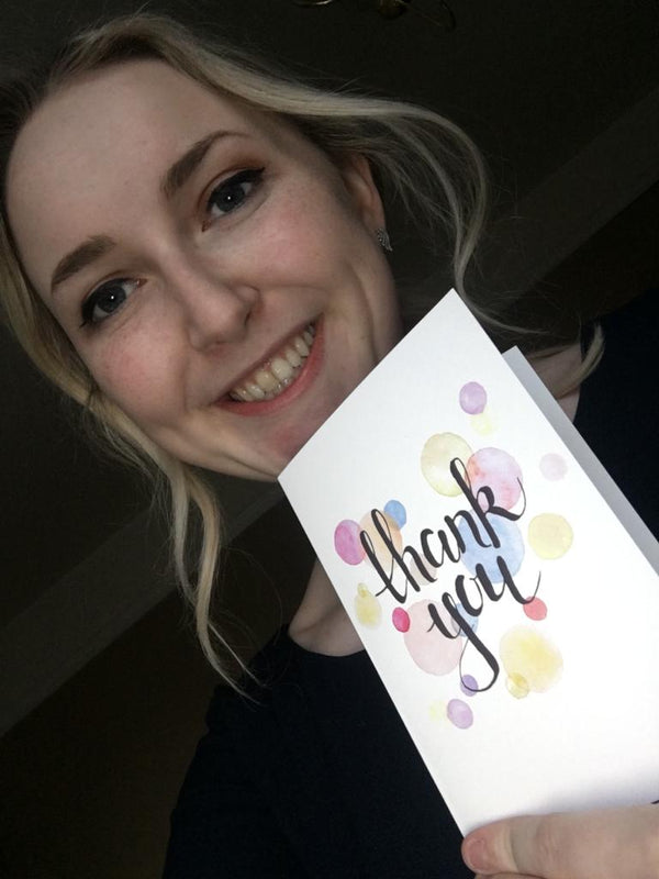 Rachel holding a thank you card from Into University